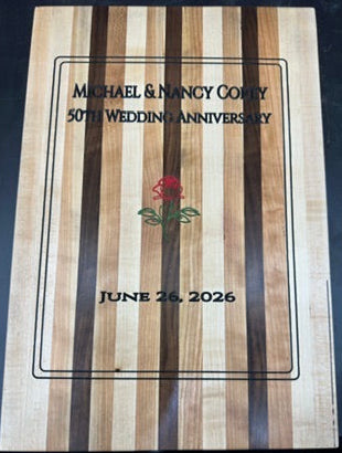Wooden plaque with engraved text and a rose design on a dark background