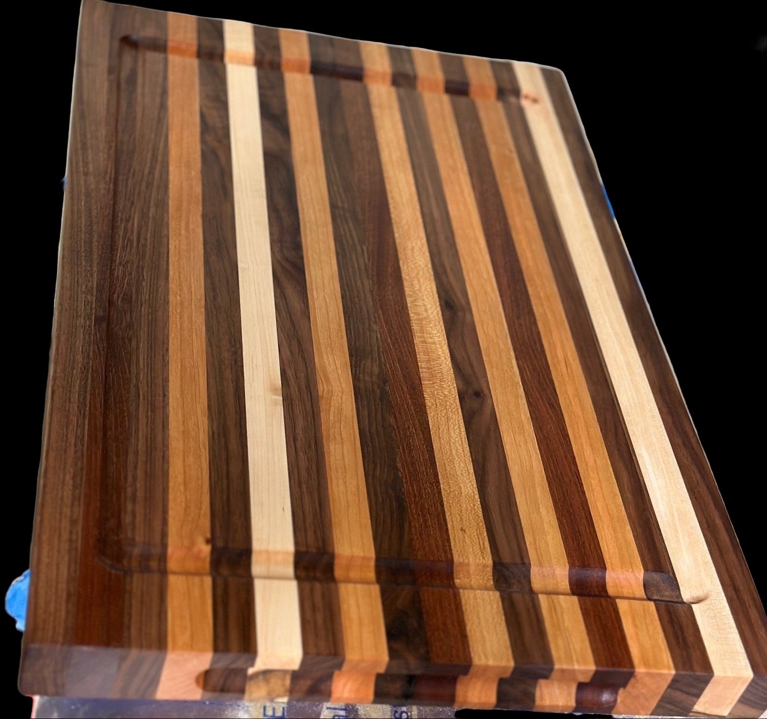 Wooden cutting board with striped pattern on a metal surface