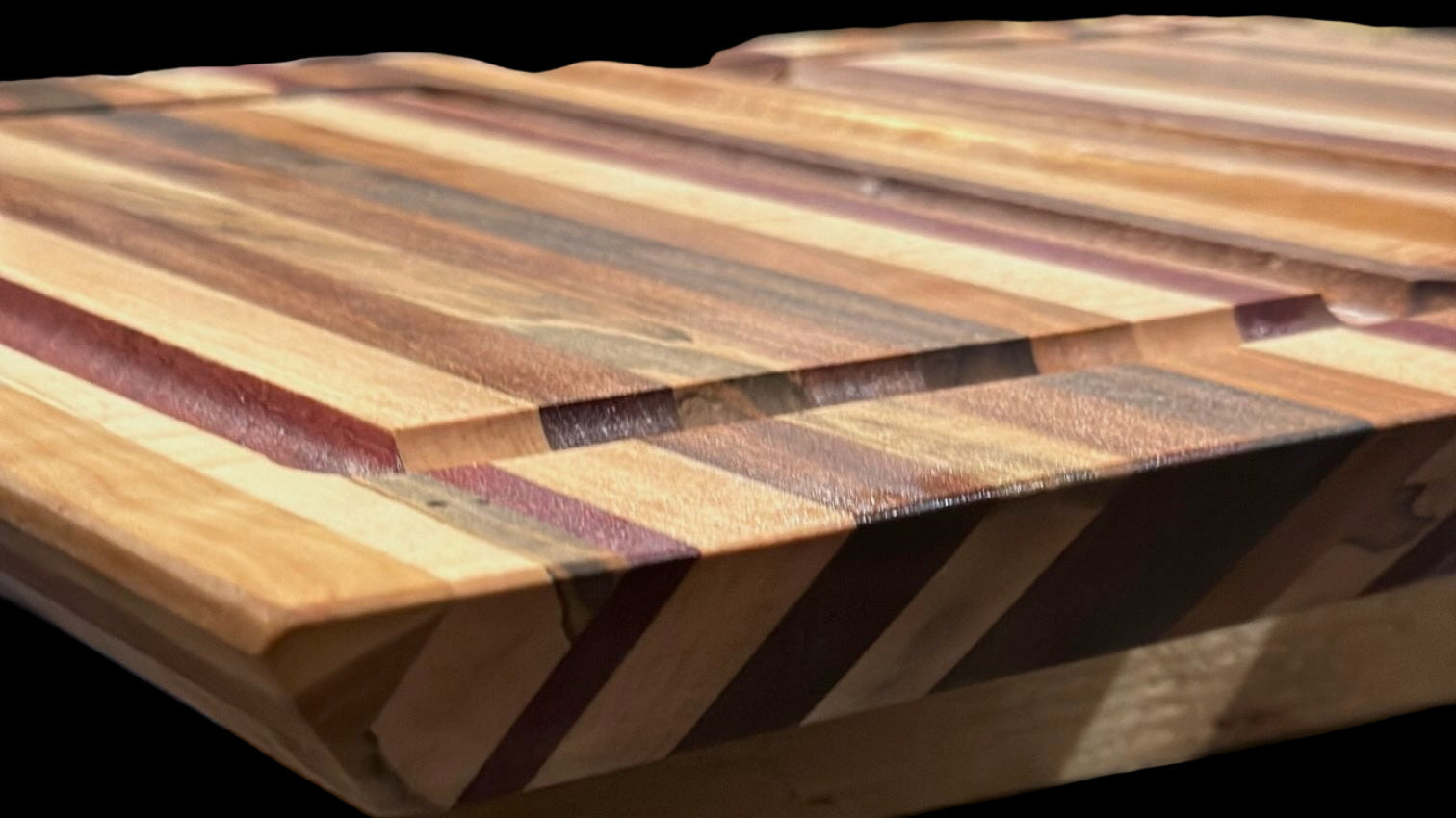 Wooden cutting board with a striped pattern on a granite countertop