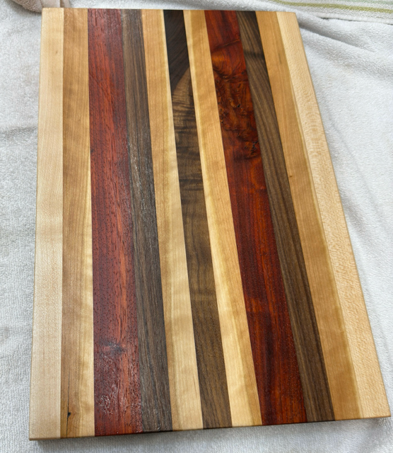 Wooden cutting board with striped pattern on a light gray background