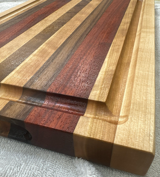 Wooden cutting board with multicolored stripes on a light background