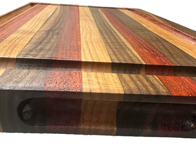 Wooden cutting board with multicolored stripes on a textured surface