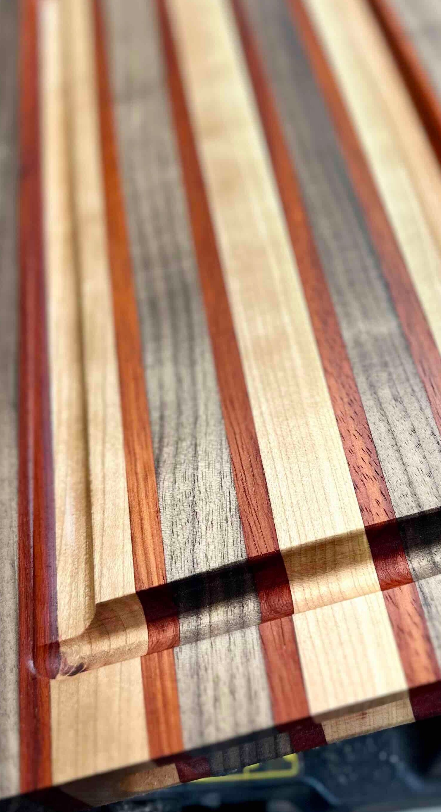 Wooden cutting board with multicolored stripes on a blurred background