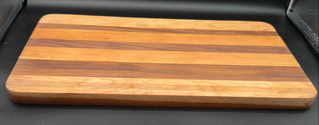 Angled view of handcrafted walnut cherry and maple serving board