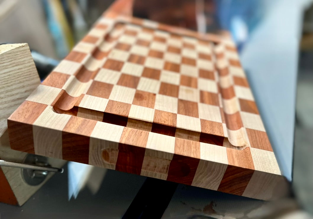 Wooden cutting board with checkered pattern on a blurred background