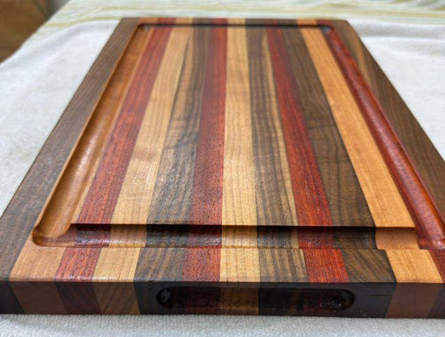 Wooden cutting board with multicolored stripes on a light background